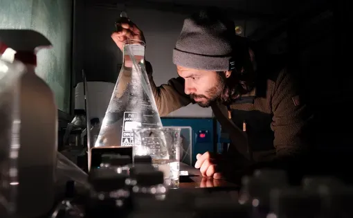 scientist looks in bottle