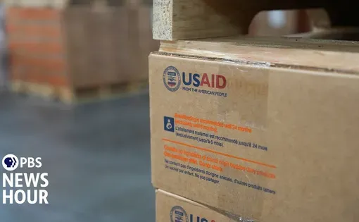 photo of boxes of USAID medical aid, with PBS NewsHour logo