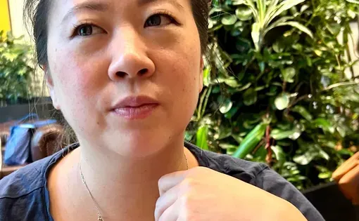 Stephanie Lee considers that challenges of pregnancy after loss while gently tugging at a necklace that features the imprint of her stillborn daughter's foot.