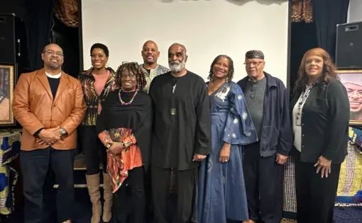 Veronica stands with presenters participating in The Ink and The Iron Event. 8 Black educators and community leaders stand together smiling at the camera.