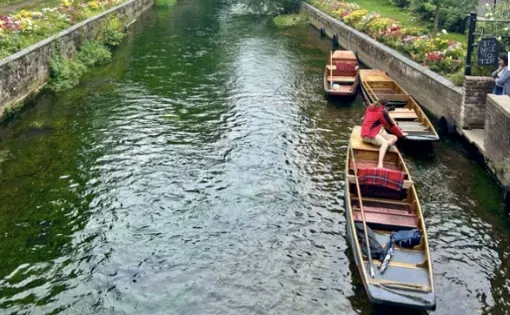 Three small canoe-like boats sit in a waterway