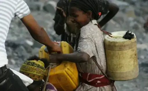 A girl carries cans of water. Image by Alex Stonehill. Ethiopia, 2008.