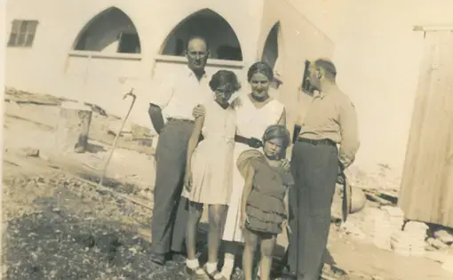 Shula Lavyel and her younger sister, Avivit, with their father (right) and his two siblings, in front of their house in Haifa being built.&nbsp;Image courtesy of Shula Lavyel.&nbsp;British Mandate of Palestine, 1935.