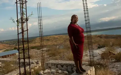 Carmen Cean, a.k.a. "Madame Roy," poses for a photo on a foundation near her home on a hilltop in the Village de Pecheur neighborhood of greater Canaan. Image by Allison Shelley. Haiti, 2019.