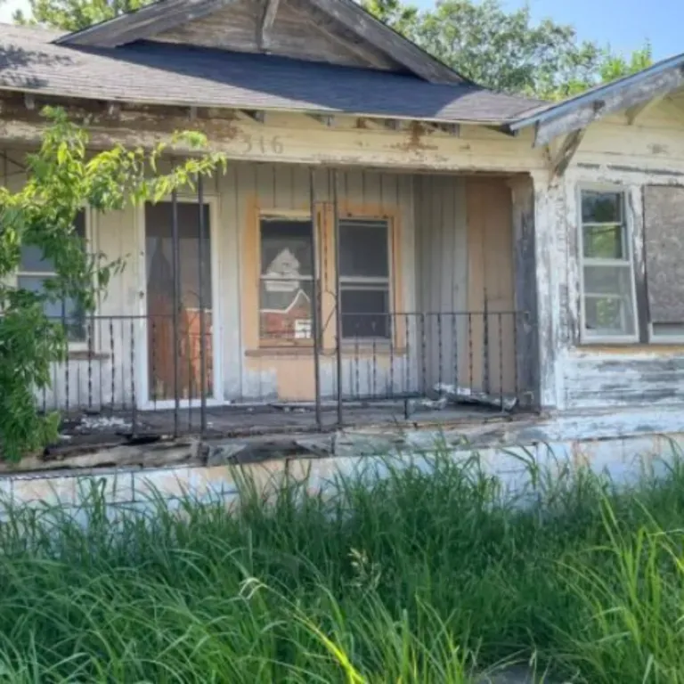 A photo of Melvin B. Tolson's home in Langston, Oklahoma shared by Oklahoma State Preservation office. An old weathered one-story home surrounded by greenery.