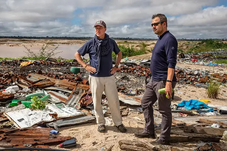 Scientists Miles Silman and Luis Fernandez survey trash left behind by gold miners in the La Pampa region of Peru. Image by Brett Gundlock. Peru, 2019.