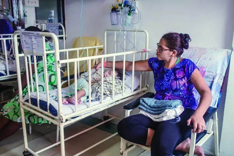 Mylene Helena dos Santos Ferreira and her son Davi wait in the hospital to speak with a doctor.&nbsp;Image by Fábio Erdos. Brazil, 2017.&nbsp;