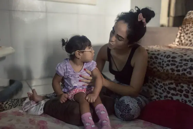 Mãe e filha: Dhulha Alen Silva do Nascimento e sua filha, Valentina compartilham um momento de silêncio em casa.&nbsp;Fotografia por Fábio Erdos Brazil, 2017.