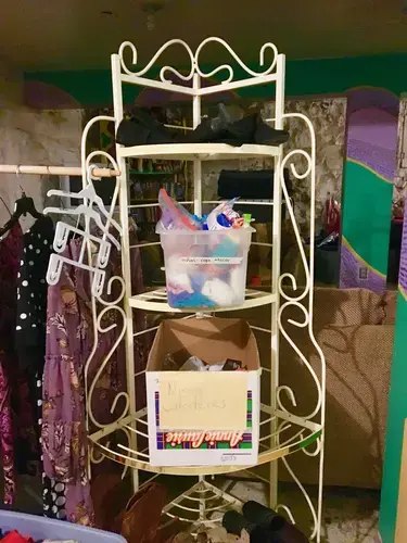 Volunteers at Casa Vides store donated clothing in the basement. After Border Patrol drops them off, new arrivals go downstairs to pick out a change of clothes. Bins labeled “niñas—ropa interior” and “Niñas Calcitenes [sic]” hold underwear and socks for children. Image by Lily Moore-Eissenberg. United States, 2019.