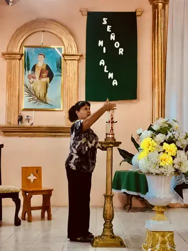 A parishioner lights a ceremonial candle before the mass.&nbsp;Image by Lily Moore-Eissenberg. Mexico, 2019.