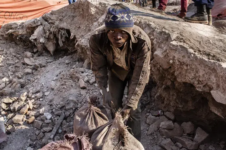 A miner ties up bags of cobalt&nbsp;inside the Congo DongFang mine in Kasulo. Image by Sebastian Meyer. Democratic Republic of the Congo, 2018.