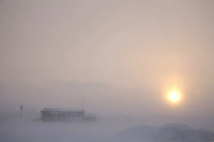 In this Feb. 13, 2019, photo, the afternoon sun hangs low as it shines through the snow at the airport in Nome, Alaska. Survivors and advocates contend that Nome police pay less attention and investigate less aggressively when sexual assaults are reported by Alaska Native women. Image by Wong Maye-E. United States, 2019.