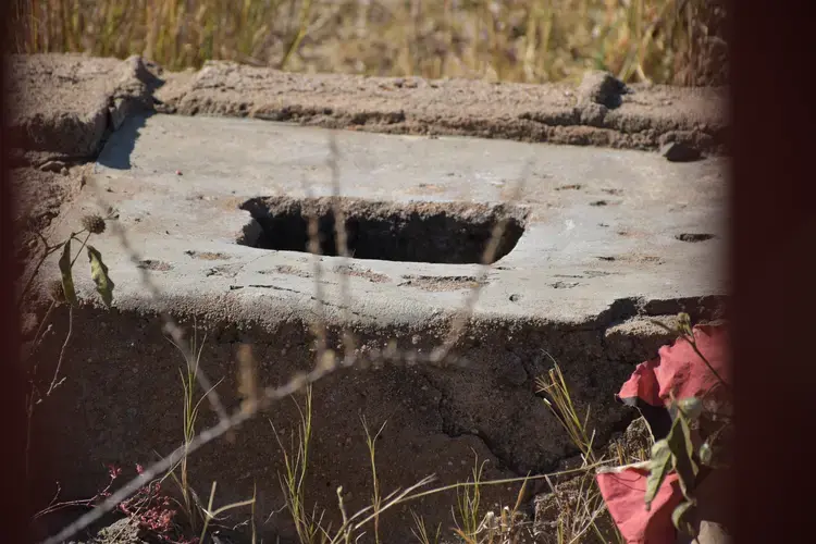 A pit toilet at Utjane that is no longer in use due to the danger it posed to learners. The school built a fence in front of the toilet&nbsp;to prevent young students from accessing it. Image by Adam Yates. South Africa, 2018.