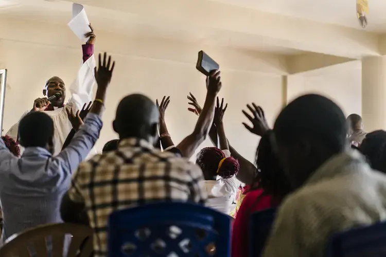 Members of the LGBT community, allies and others gather for a church service led by gay, black American pastor Joseph Tolton. Tolton comes to East Africa several times a year to mentor local pastors in 'radical inclusivity' and to be more welcoming to the LGBT community. He and others like him are in some ways the anti-Scott Lively.&nbsp;Image by Jake Naughton. Uganda, 2017.