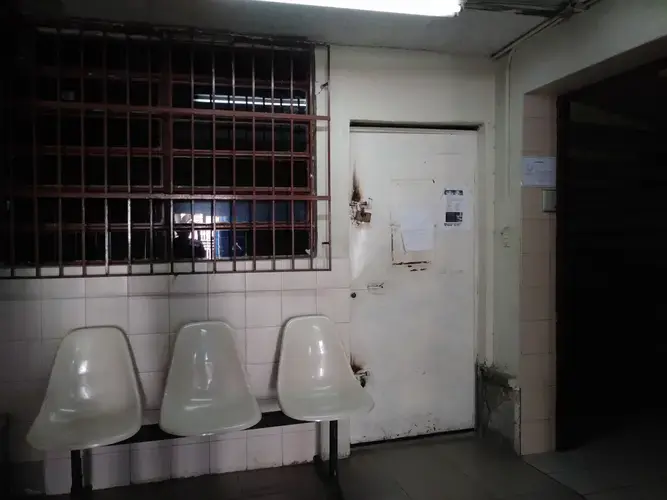 The waiting room at Clinica Riverside, in East Caracas, where Carlos Román receives dialysis three&nbsp;times a week, is a dark room with dim white light and rusty white metal chairs. Family members and visitors are not allowed inside the dialysis unit and must wait outside until the patient's session is finished.