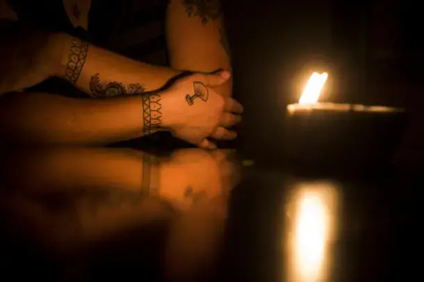 Saunders shows a tattoo of an ulu, Inuit cutting tool, on her right hand with traditional Inuit tattoos on both wrists illuminated by a whale oil lamp at her apartment in the military base town of Happy Valley-Goose Bay, Labrador. Image&nbsp;by Michael G. Seamans. Canada, 2019.
