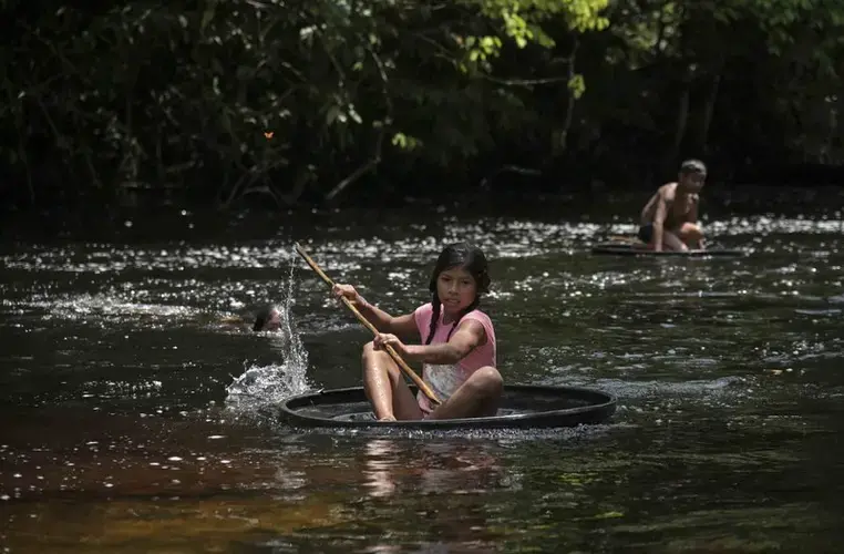 A girl sails on a float, made from a tire, over the stream in the community of Timbó. Image by Luis Ángel. Colombia, 2019.