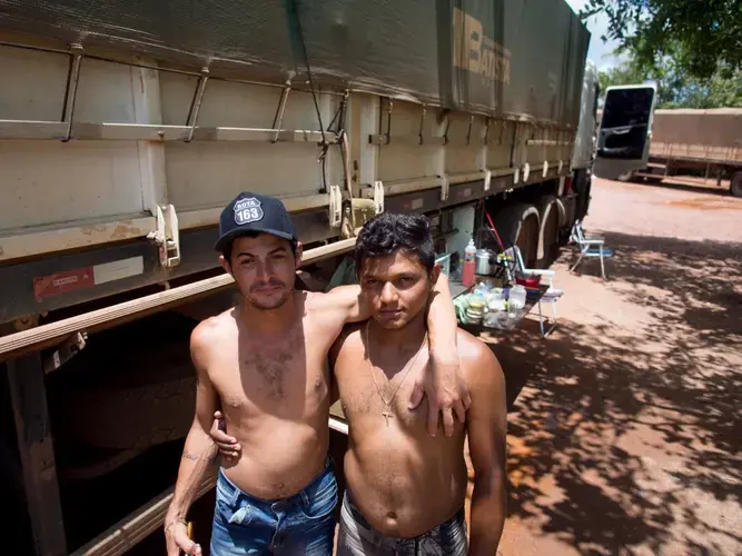 Two young truck drivers who transport soy via highway BR-163 fear the impact of the 'grain train' on their jobs -- the railway promises to cut the costs of transporting product. Image by Heriberto Araújo. Brazil, 2019.