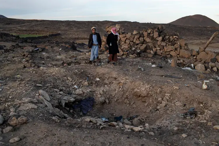 Jamal Muhammad Ali Qied (left), whose 14-year-old brother was killed in the airstrike, and Yahia al-Abdeli, who was injured and whose brother was killed, at the site of the attack. Image by Tyler Hicks/The New York Times. Yemen, 2018.
