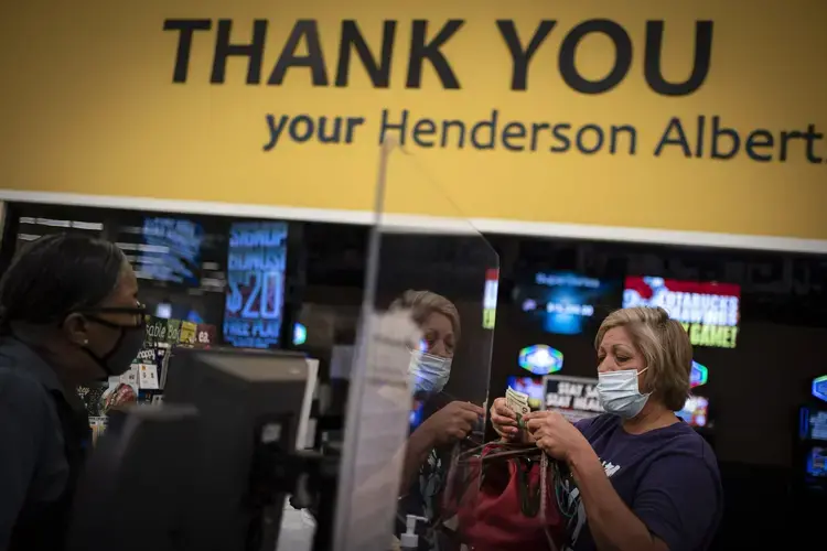 Norma Flores, 54, pays for her groceries at a store near her home in Henderson, Nev., Tuesday, Nov. 10, 2020. Image by Wong Maye-E / AP Photo. United States, 2020.