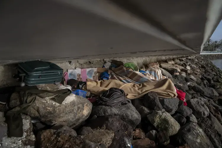 Khalid, a migrant from Gambia, sleeps on a breakwater under a bridge in Gran Canaria island, Spain, on Saturday, Aug. 22, 2020.&nbsp;Image by Emilio Morenatti/AP Photo. Spain, 2020.