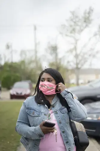 Founder of Lake Charles Black Business Owners Tasha Guidry, who is leading local voter education amidst a pandemic and two back-to-back hurricanes, puts her face mask on before entering the SWLA Center for Health Services. Image by Katie Sikora. United States, 2020.
