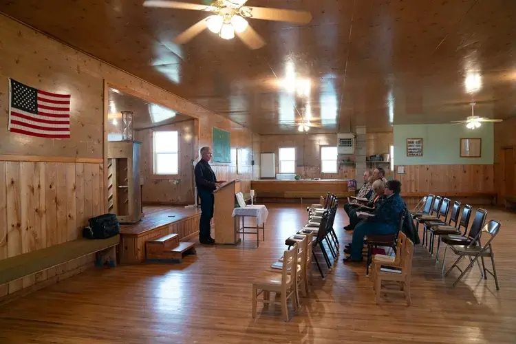 Pastor Hal DeBoer preaches to a small group of ranchers in northeastern Montana. The community is driven by the Christian notion of stewarding the land. “[God] planted the Garden so he’s for the farming profession,” DeBoer said. Image by Claire Harbage. United States, 2019.