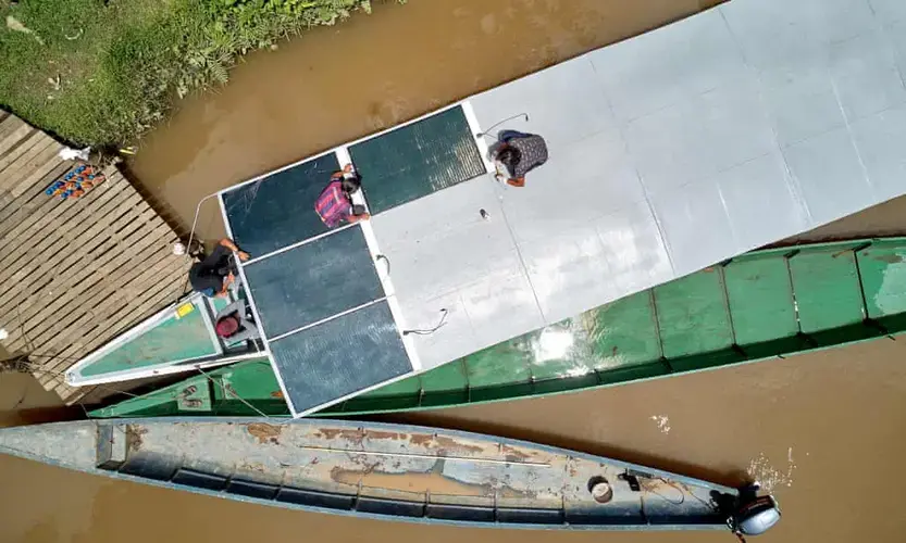 A team of indigenous technicians installs solar panels on the roof of a new canoe. Image by Pablo Albarenga. Ecuador, 2020.