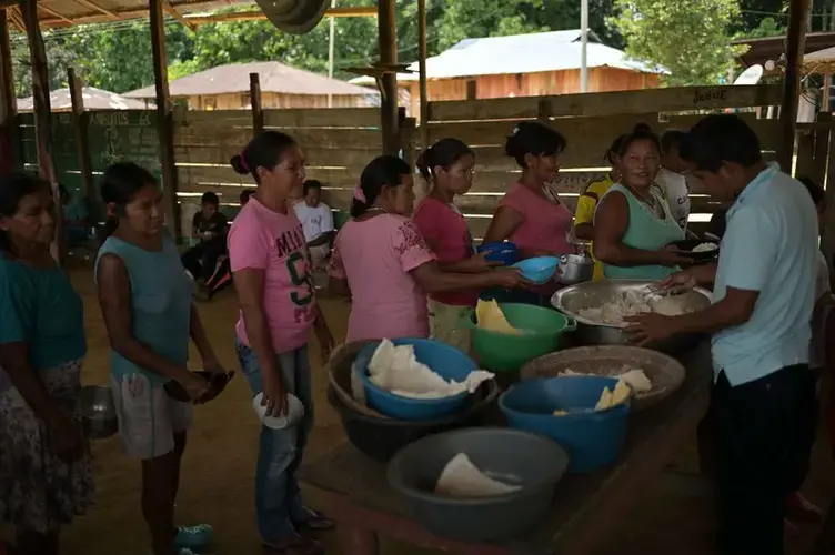 The community meets every morning at the community kiosk to share food. This traditional activity is known as quiñapira. Image by Luis Ángel. Colombia, 2019.