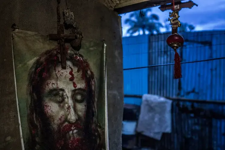 Religious icons in Remy Fernandez’s house. The archbishop of Manila, Cardinal Luis Antonio Tagle, recently denounced extrajudicial killings after the death of a 17-year-old student in Caloocan sparked nationwide protests. 'We knock on the consciences of those who kill even the helpless, especially those who cover their faces... to stop wasting human lives,' he said. The Senate has put forward a resolution condemning the killings. Image by James Whitlow Delano. Philippines, 2017.
