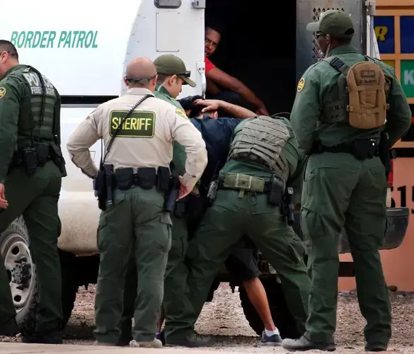 Border Patrol agents take two men into custody as they search for several undocumented migrants near the intersection of East Ajo Way and East Benson Highway. Agents took at least four people into custody in last Tuesday’s operation. Image by Mike Christy / Arizona Daily Star. Guatemala, 2019.<br />