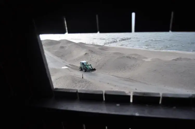 A small tractor, seen through a wildlife-watching tower, travels between dunes on an artificial island in Lake Marken, the Netherlands.&nbsp;Image by Tristan Baurick / Times-Picayune | The Advocate. The Netherlands, 2020.