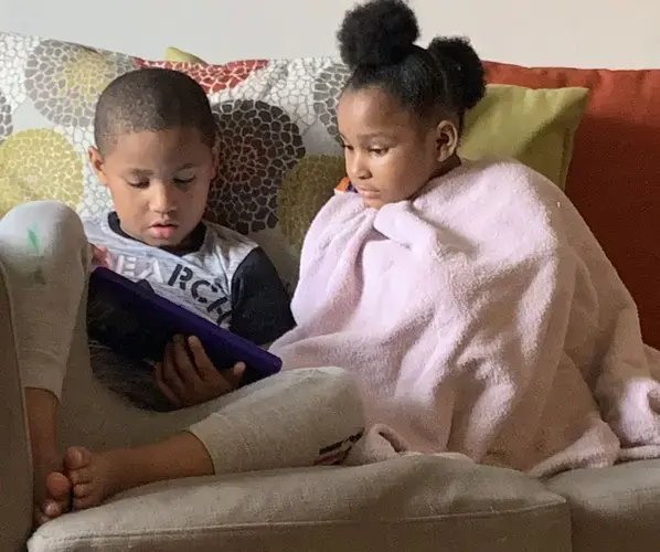 Meegale and Madison Hundley share a tablet to play an educational game during the pandemic. Image by Aisha Sultan / Post-Dispatch. United States, 2020.