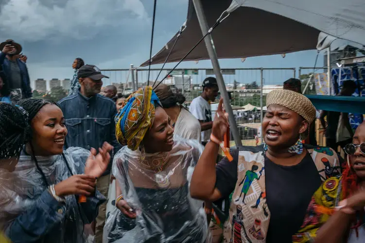 While the Afropunk Joburg festival was on pause because of the weather, crowds make their own music, singing freedom songs. Image by Melissa Bunni Elian. South Africa, 2017.