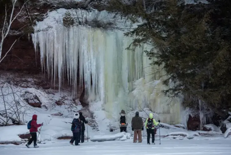 Tourists from Madison, Wisconsin, experience ice formations during a tour of ice caves on the shore of Lake Superior in the Red Cliff reservation in Wisconsin on Feb. 15, 2020. Image by Zbigniew Bzdak/The&nbsp;Chicago Tribune​​​​​​​. United States, 2020.