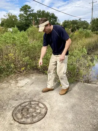 Jimmy “Zeke” Mazyck explains how he found a chokepoint that made his neighborhood off Central Park Drive on James Island flood worse than it should. Image by Tony Bartelme/The Post and Courier&nbsp;Staff. United States, 2020.