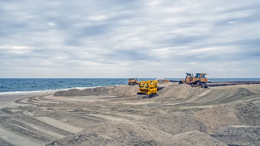 Heavy equipment sculpts renourished sand into berms. Image courtesy of NJ Spotlight. United States, undated.