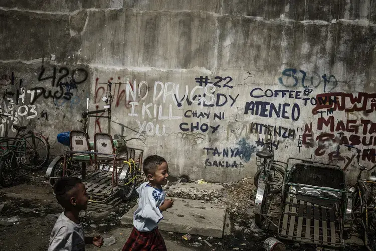 Graffiti on a wall on the main road just outside one of Manila’s slums. Last year, the police embarked on a nationwide campaign called Oplan Tokhang, knocking on doors of those suspected of drug use and “pleading” with the occupants to stop using. But the reality, critics say, is far bloodier. Image by James Whitlow Delano. Philippines, 2017.