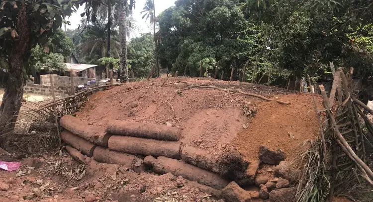 Smothering&nbsp;wood in a process that will create approximately 26,400 pounds&nbsp;of charcoal. Image by Kadia Goba. Sierra Leone, 2018.