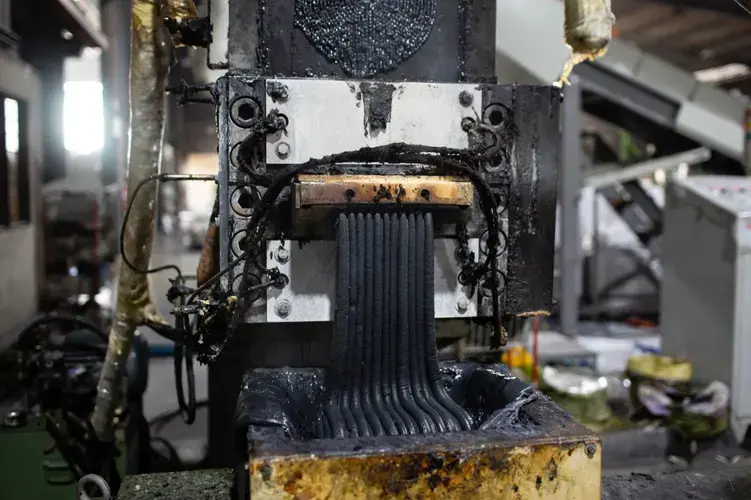 Molten plastic exits an extruder at the YB Enterprises recycling factory in Padang Serai, Malaysia. Health and environmental problems near such factories have sparked anger and opposition in local communities. Image by Sebastian Meyer. Malaysia, 2020.