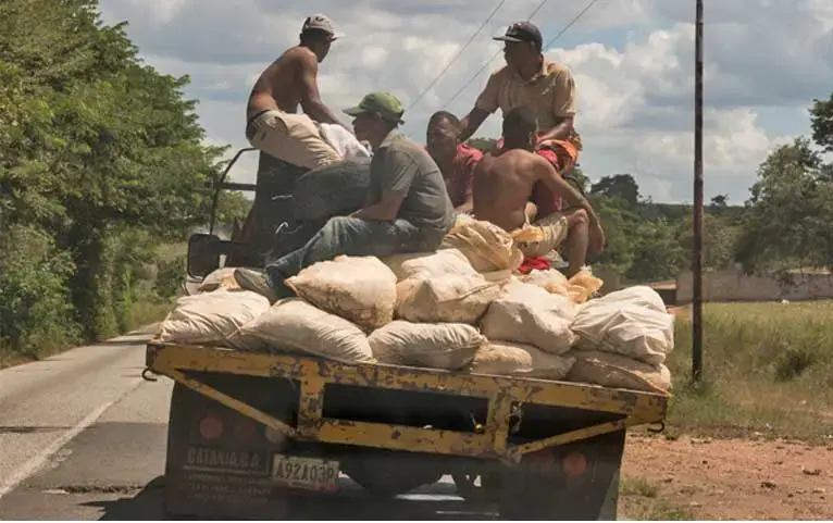 Small-scale miners in Bolívar state transport mineral ore to one of the nearby processing mills. They are rarely well rewarded for their grueling work yet suffer major risks to health and their lives. Image by Bram Ebus. Venezuela, 2017.<br />