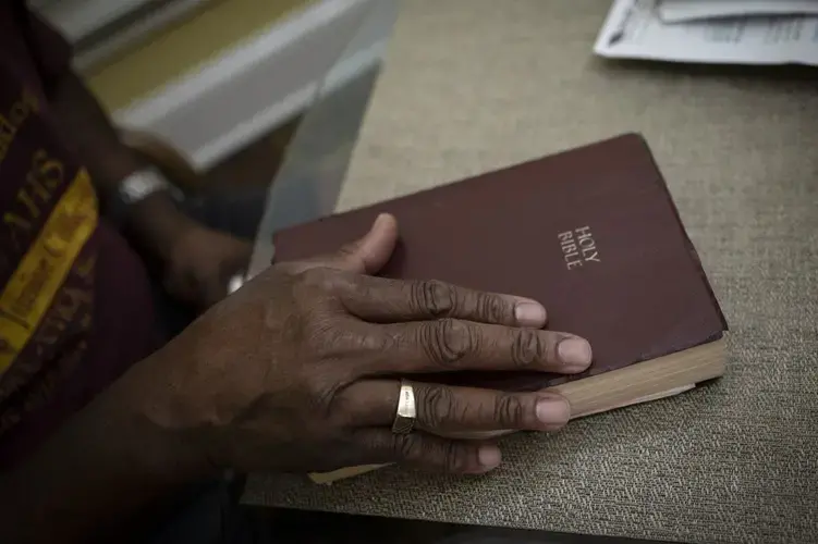 Mike Bishop closes his Bible after reading a passage from the Book of Psalms. Image by Wong Maye-E/AP Photo. United States, 2020.