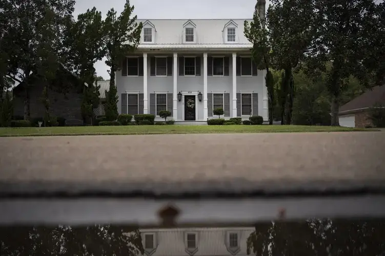 The house of Mike and Bonnie Bishop is reflected in a puddle. Image by Wong Maye-E/AP Photo. United States, 2020.