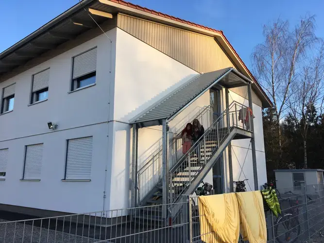 Two Daas sisters exit the refugee housing complex in Traunreut, Bavaria, where they are living until they can find their own permanent housing. Image by Jeanne Carstensen. Germany, 2017. 
