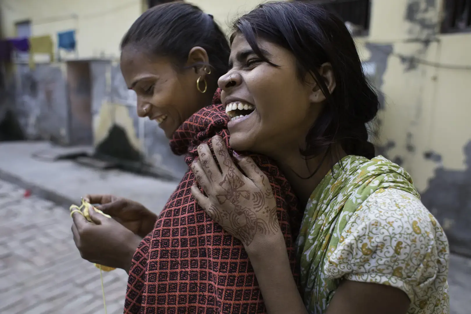 Friends socialize at Tarash Mandir, a short-stay home for young women and permanent facility for elderly widows in Vrindavan. Image by Amy Toensing. India, 2016. Two friends laugh together