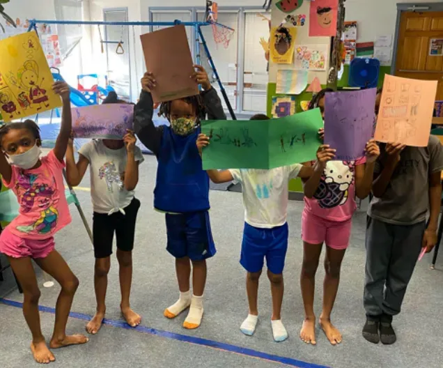 students hold up colorful signs