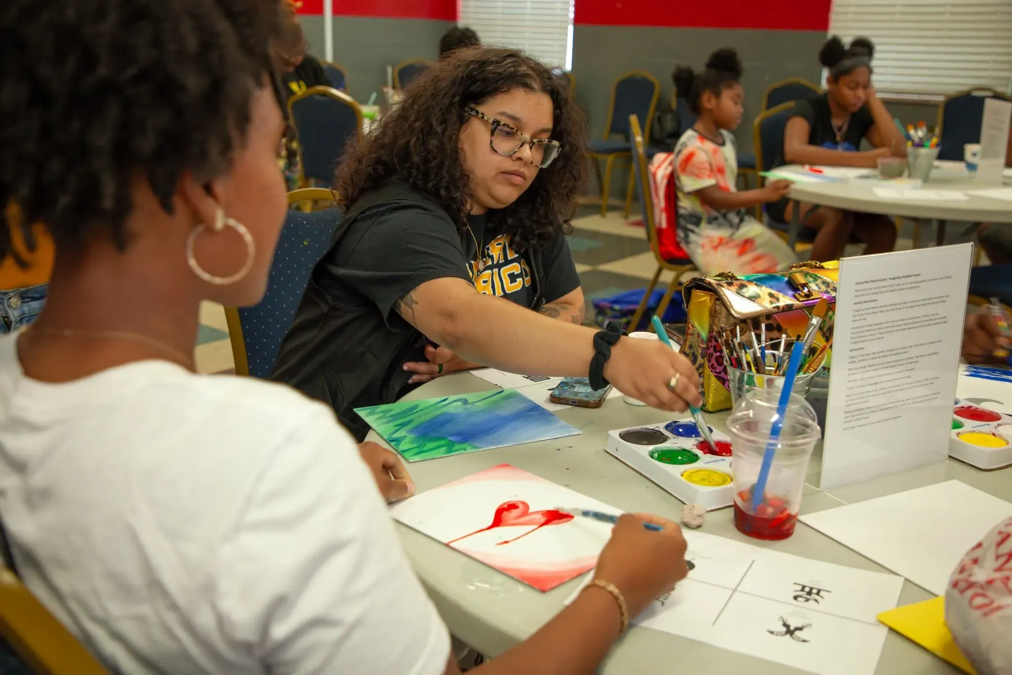 People sit at a table painting watercolors