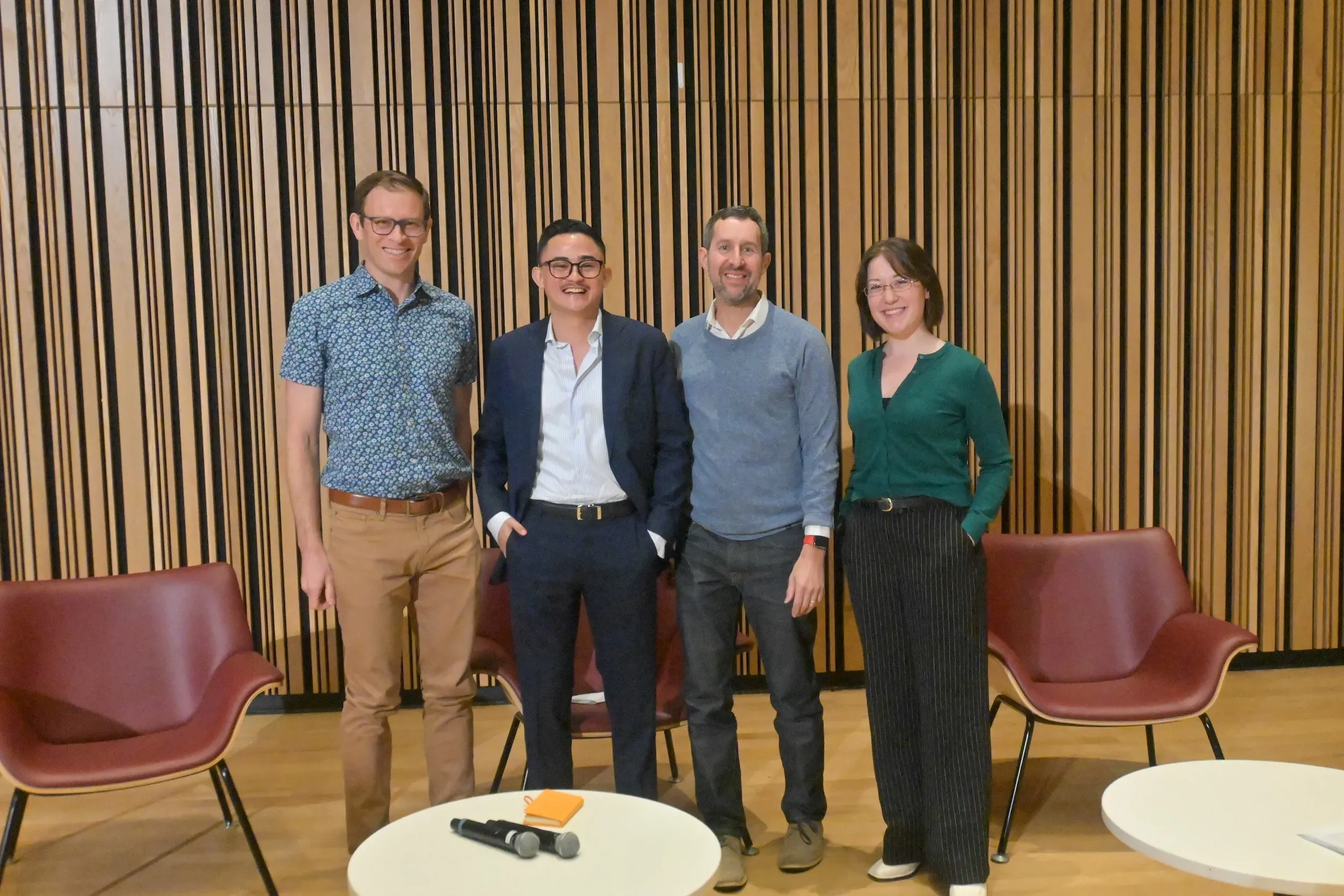 Four people in business clothes stand together for a photo