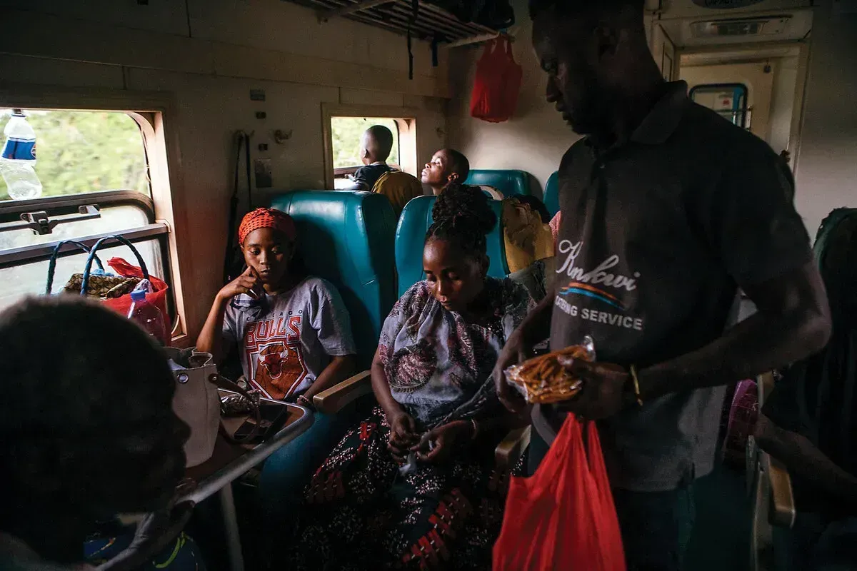 A vendor sells snacks to passengers in the third-class train of the Tazara. Image by Kang-Chun Cheng.