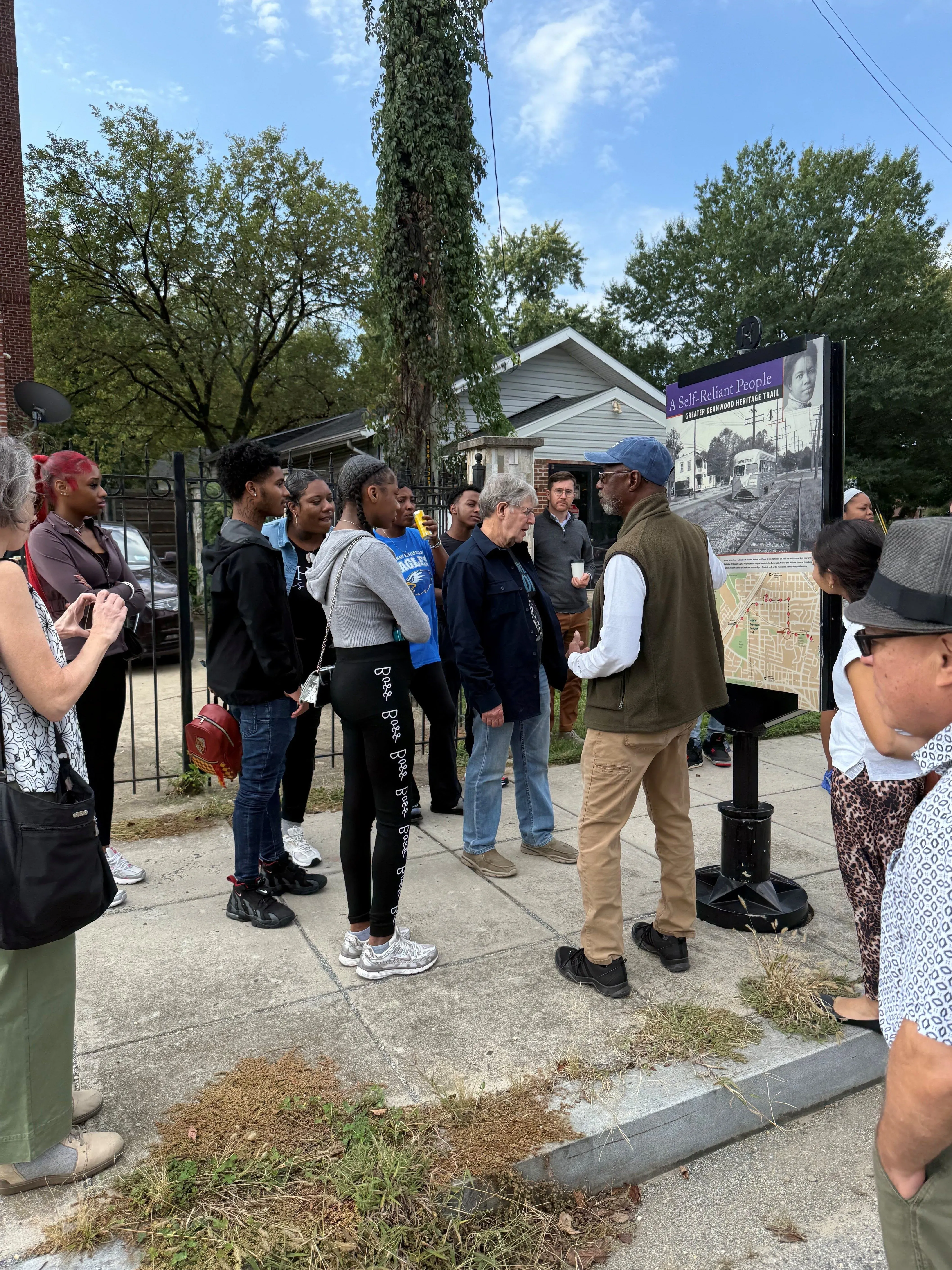 community members look at a historical sign in Washington D.C. Ward 7. 